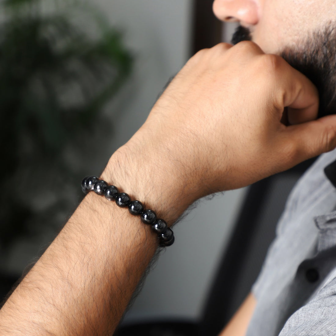 A close-up of a handmade bracelet featuring smooth round hypersthene gemstone beads, showcasing their captivating black color.