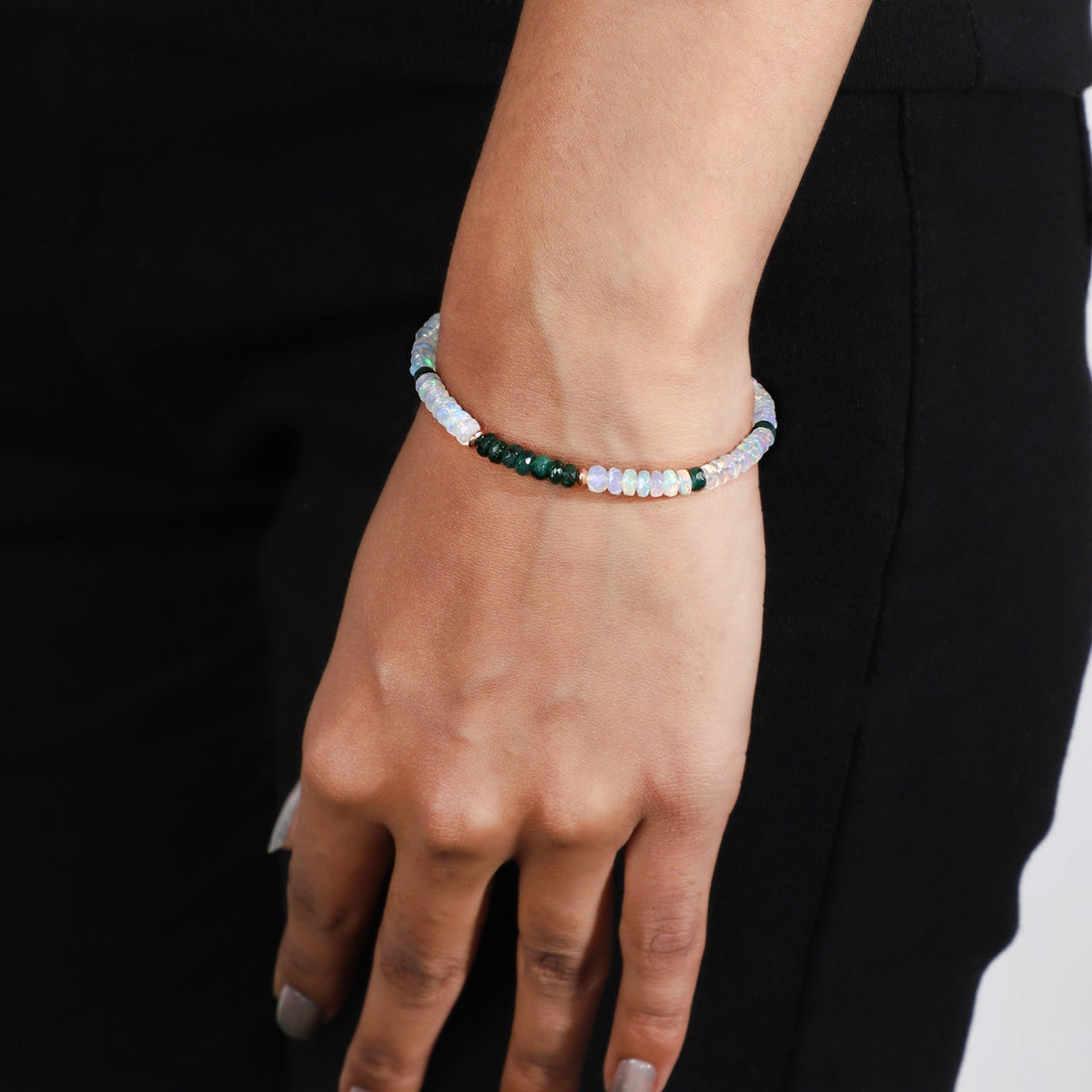 Close-Up of Faceted Rondelle Opals and Emeralds on Silver Bracelet