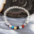 A vibrant bracelet adorned with smooth round gemstone beads, including Rose Quartz, Turquoise, Amethyst, and more, creating a colorful and harmonious arrangement.