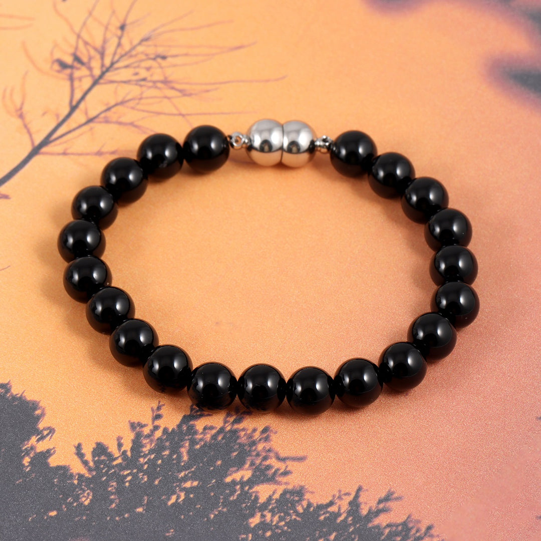 An image featuring the black onyx gemstones alongside keywords like protection, grounding, and self-control, symbolizing their metaphysical properties.