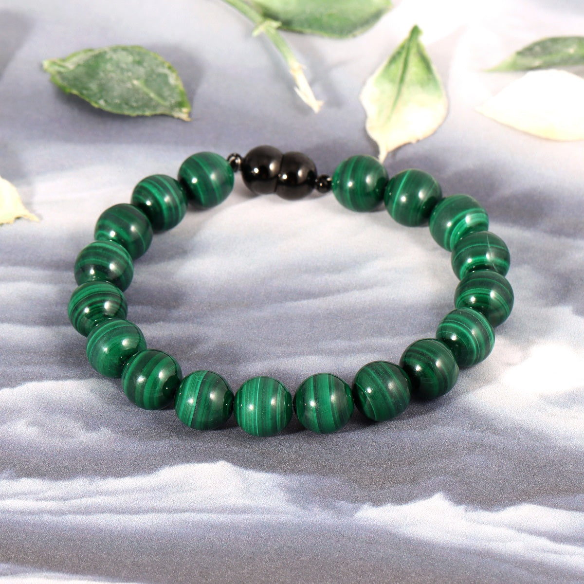 An image featuring the malachite gemstones alongside keywords like transformation, protection, and balance, symbolizing their metaphysical properties.