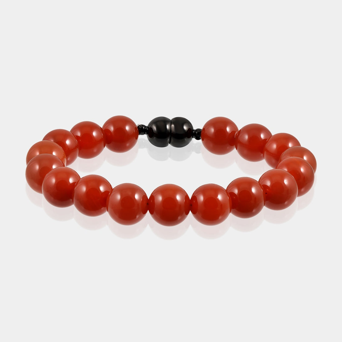 A close-up of a handmade bracelet featuring smooth round red onyx gemstone beads, showcasing their striking and alluring red color.