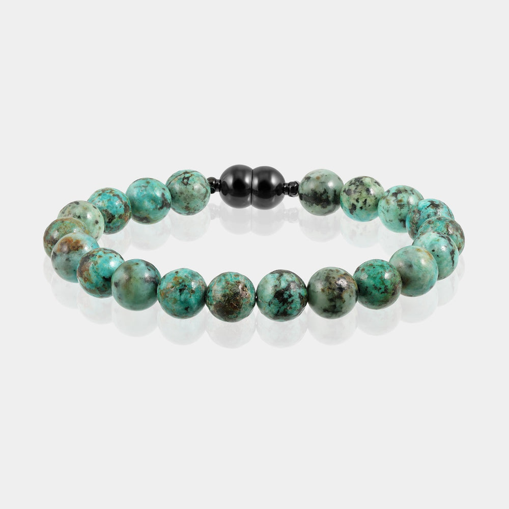 A close-up of a handmade bracelet featuring smooth round turquoise gemstone beads, showcasing their captivating green color.