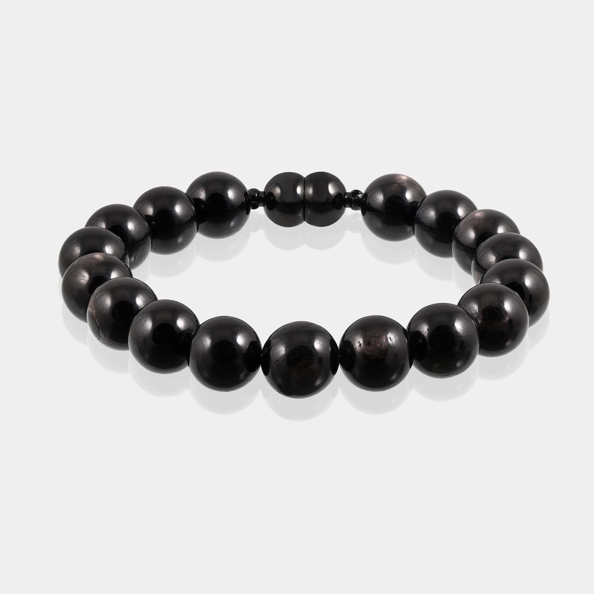 A close-up of a handmade bracelet featuring smooth round hypersthene gemstone beads, showcasing their captivating black color.