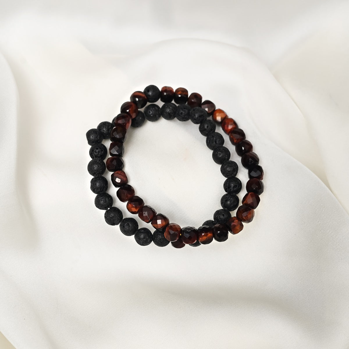 Artistic close-up of the Red Tiger's Eye & Lava Gemstone Bracelet. A captivating shot capturing the fiery red hues of Tiger's Eye and the raw elegance of lava gemstones, creating a unique and eye-catching composition.