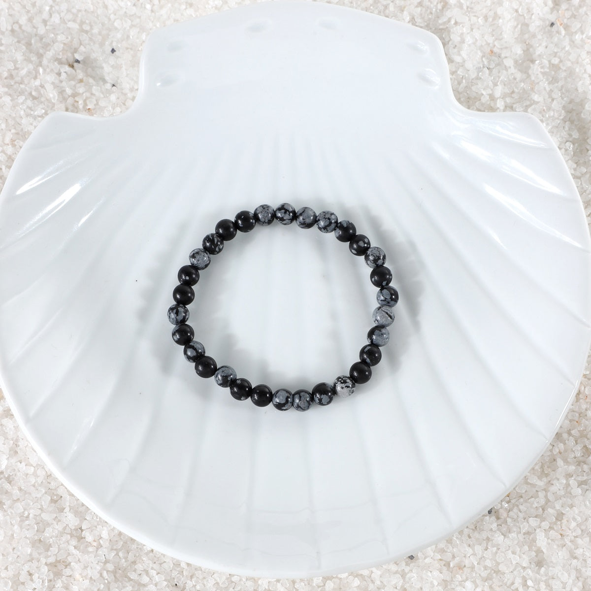 A captivating shot of the Snowflake Obsidian Bracelet in natural light, emphasizing its beauty and promoting a sense of equilibrium and focused composure.