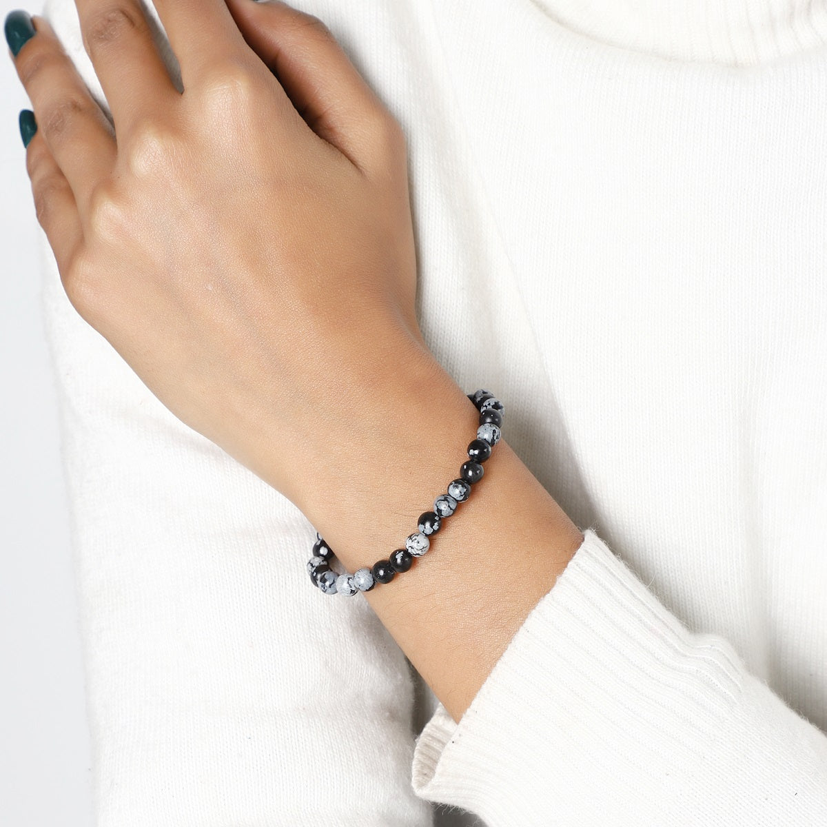 A lifestyle image featuring the Snowflake Obsidian Bracelet being worn, demonstrating its seamless integration into everyday fashion with a touch of grounding energy