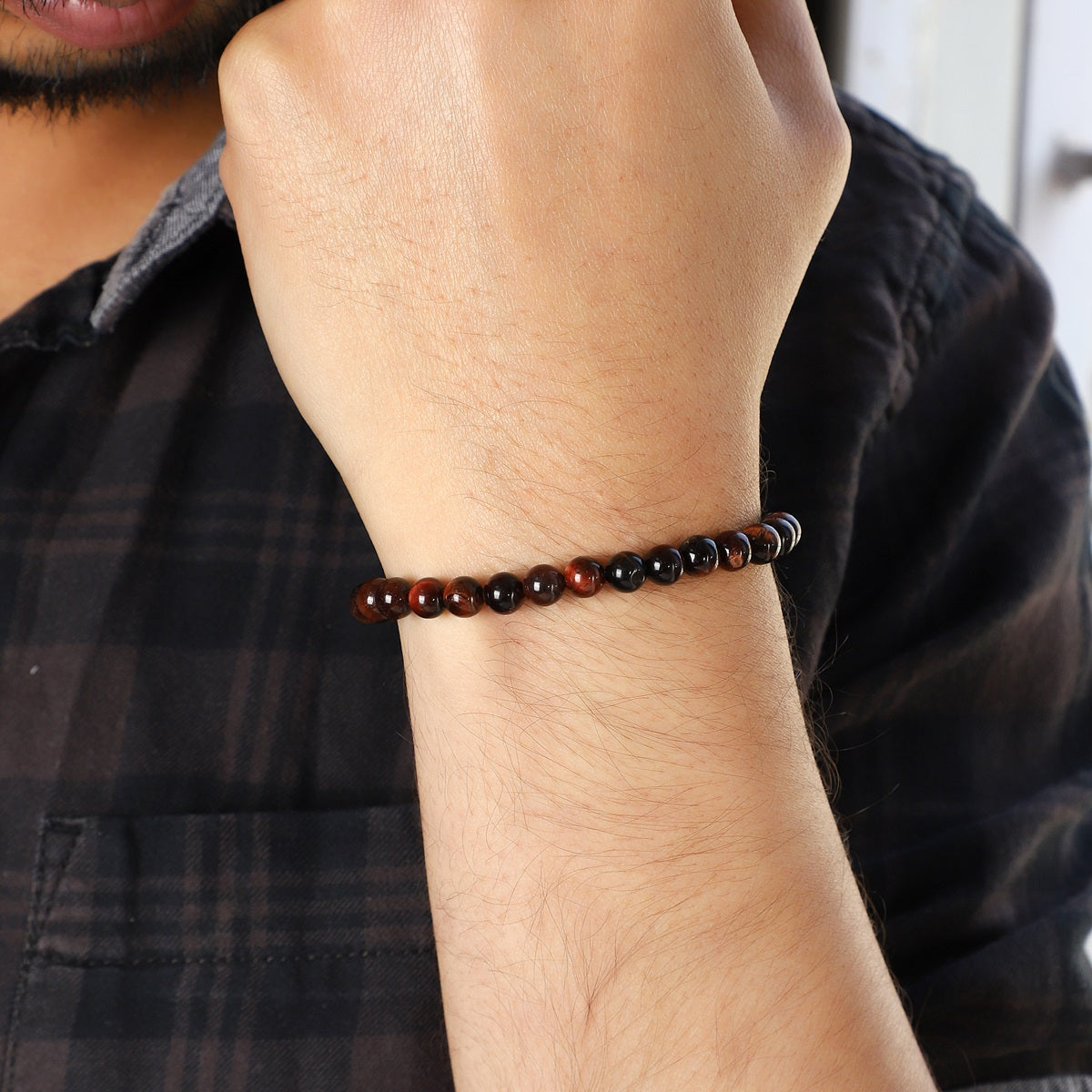 Stylish view of the Red Tiger's Eye Bracelet with 6mm smooth round beads, radiating courage and empowerment for a fashionable and bold accessory