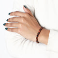 A lifestyle image featuring the Red Tiger's Eye Bracelet being worn, demonstrating its seamless integration into everyday fashion with a touch of empowerment