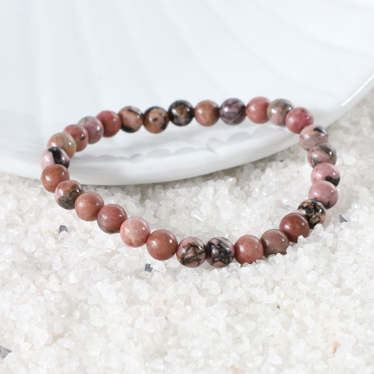 Various styling ideas for the Rhodonite Stretch Bracelet, demonstrating its versatility as a chic accessory with transformative energies of love and compassion