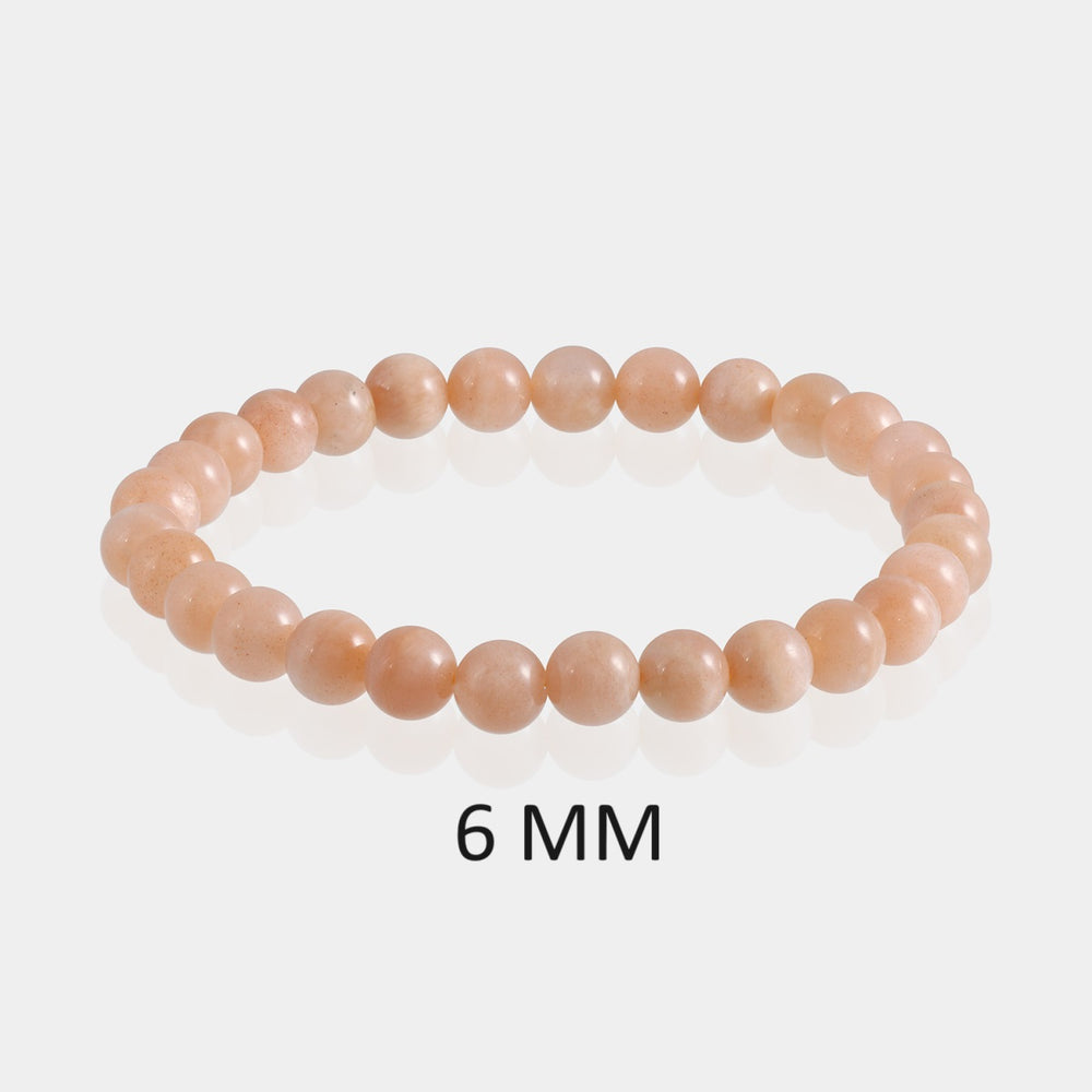 Detailed image showcasing the exquisite 6mm smooth round beads of Peach Moonstone, highlighting their soft peach hues and gentle sheen associated with emotional wellbeing