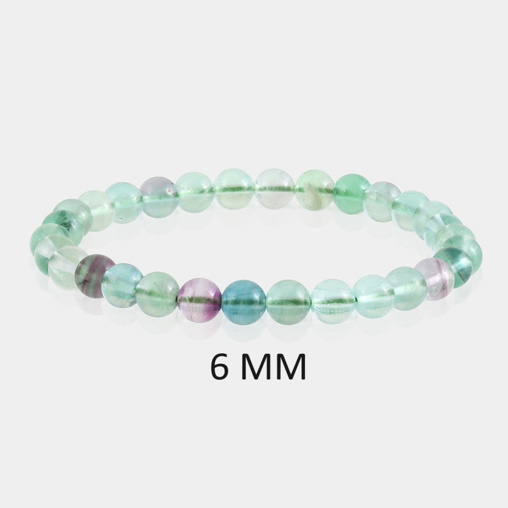 Detailed image showcasing the exquisite 6mm smooth round beads of Fluorite, highlighting their varied hues associated with enhanced focus and positive personal development