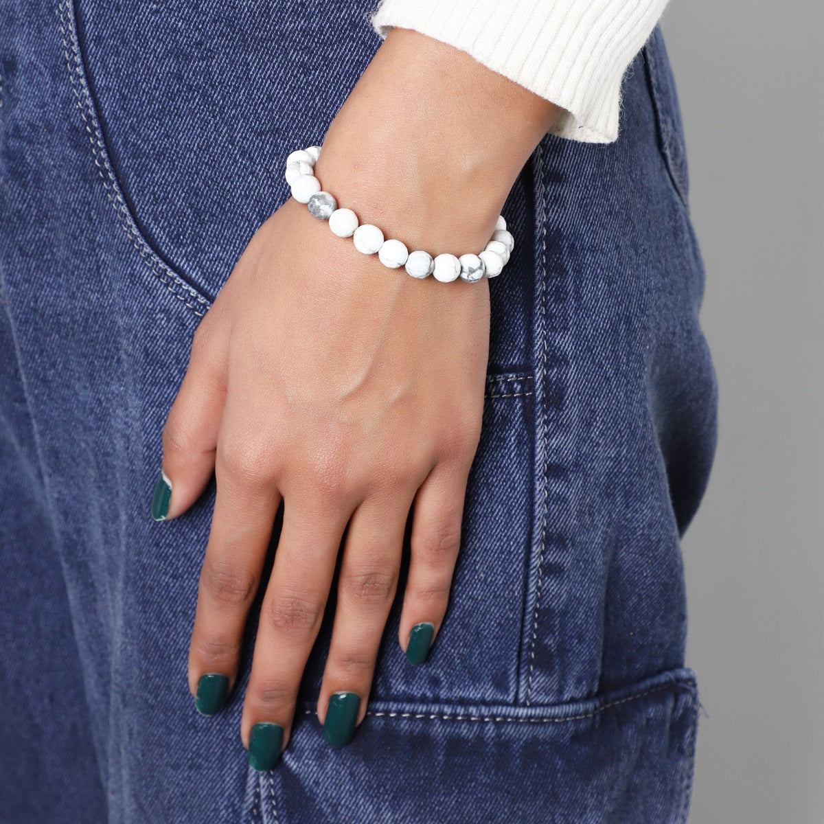  lifestyle image featuring the Howlite Stretch Bracelet being worn, demonstrating its seamless integration into everyday fashion with a touch of spirituality.