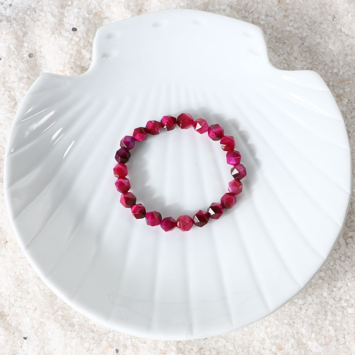 Woman wearing Pink Tiger's Eye Stretch Bracelet with 8mm faceted star cut beads for elegance and balance