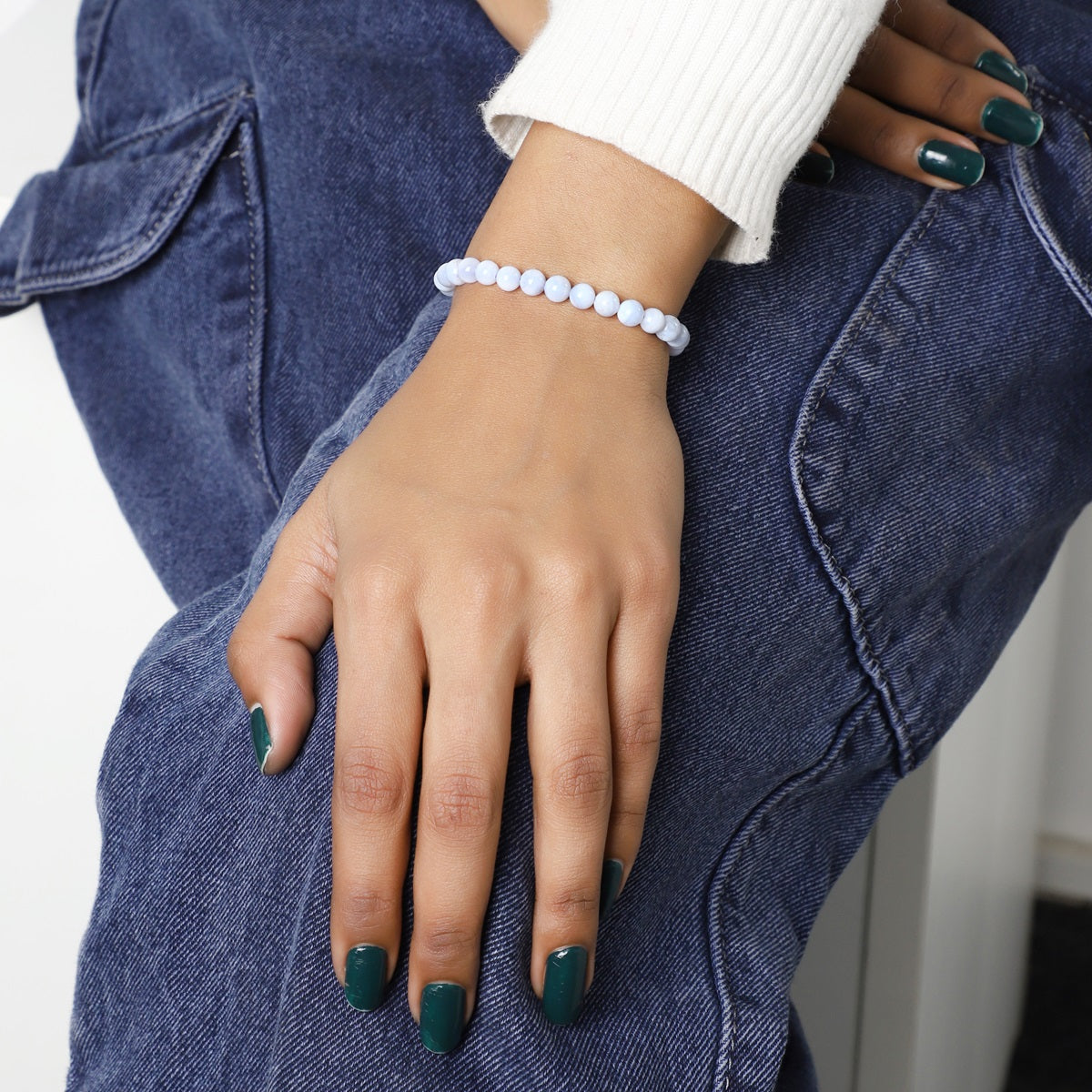 Adorned wrist featuring the Blue Lace Agate Stretch Bracelet, the Stone of Calmness