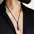 A stunning pendant necklace featuring a natural Lapis Lazuli gemstone wrapped in an intricate design.