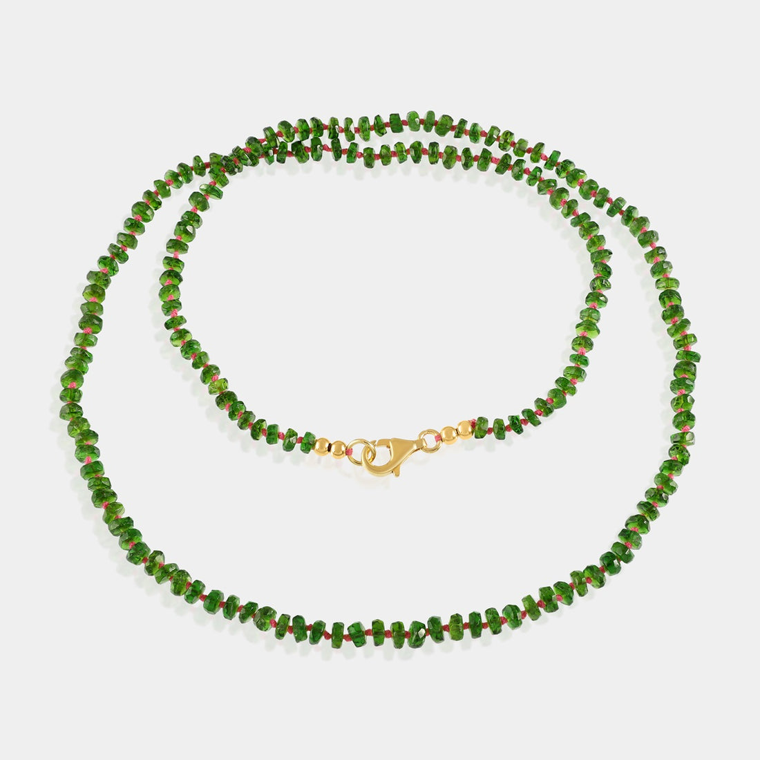 Intricately knotted thread securing Chrome Diopside gemstone beads