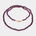 Intricately knotted thread securing Purple Garnet gemstone beads