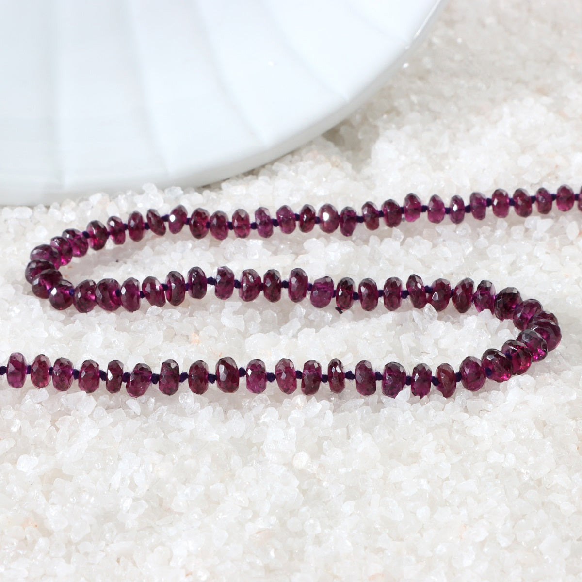 Close-up of faceted rondelle Purple Garnet gemstone beads on necklace