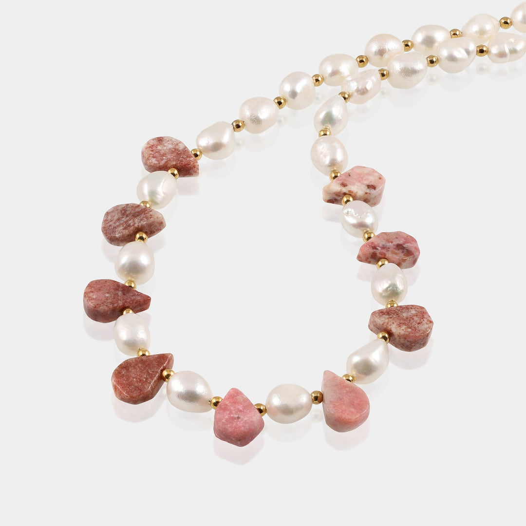 Smooth pear-shaped rhodochrosite gemstone in a soft pink hue