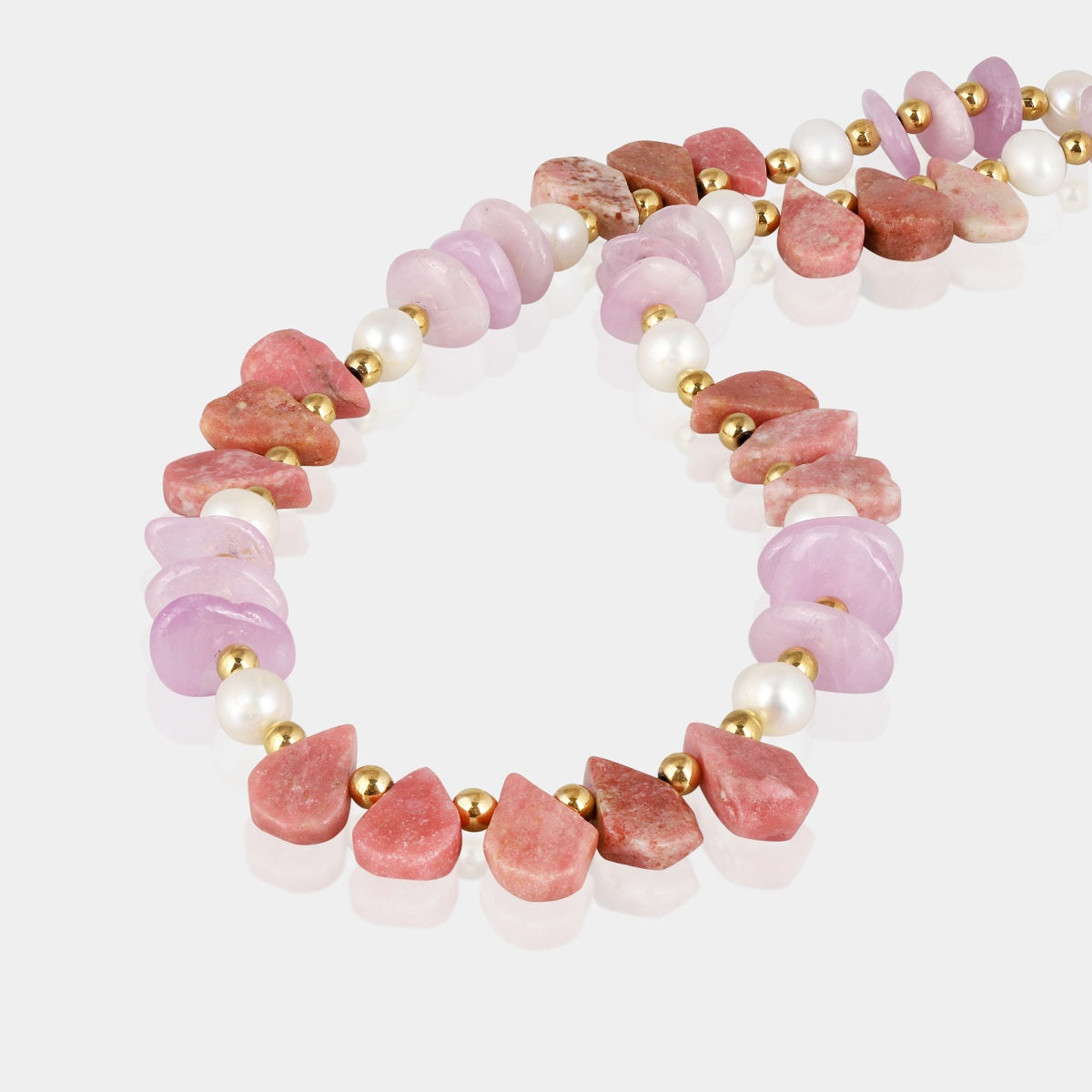 Close-up of smooth pear-shaped Rhodochrosite gemstone beads on silver necklace