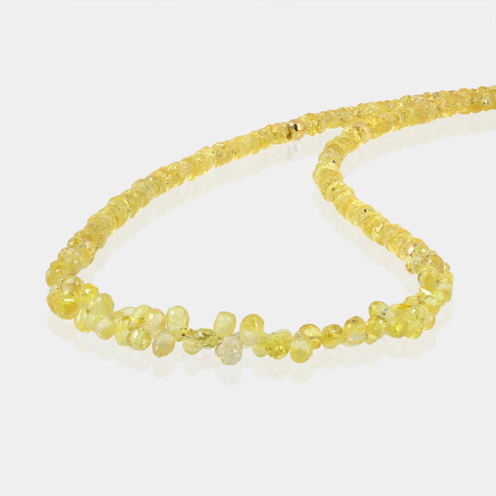 Close-up of faceted rondelle Yellow Sapphire gemstone beads on silver necklace