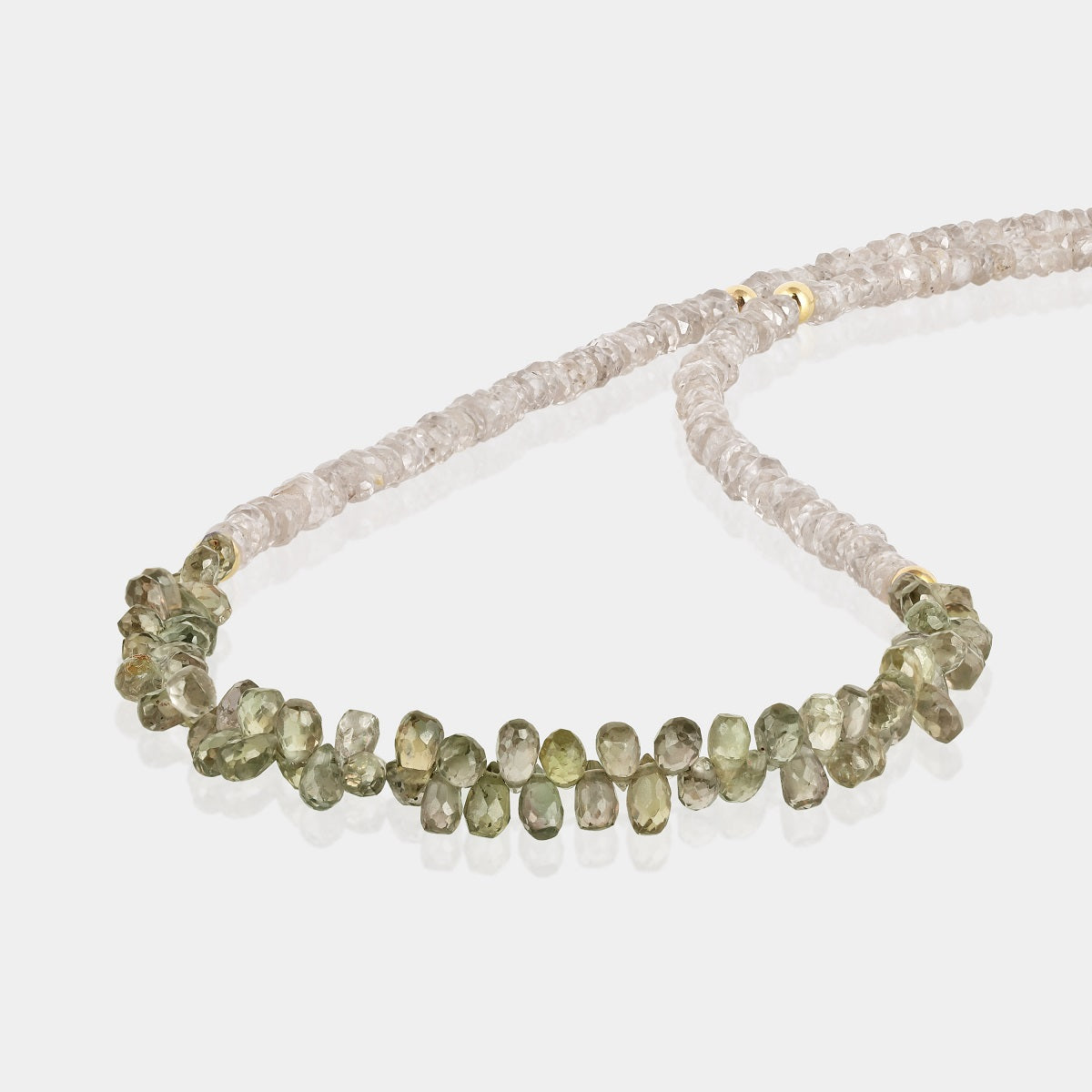 Close-up of faceted drop-shaped champagne sapphire gemstone beads on silver necklace