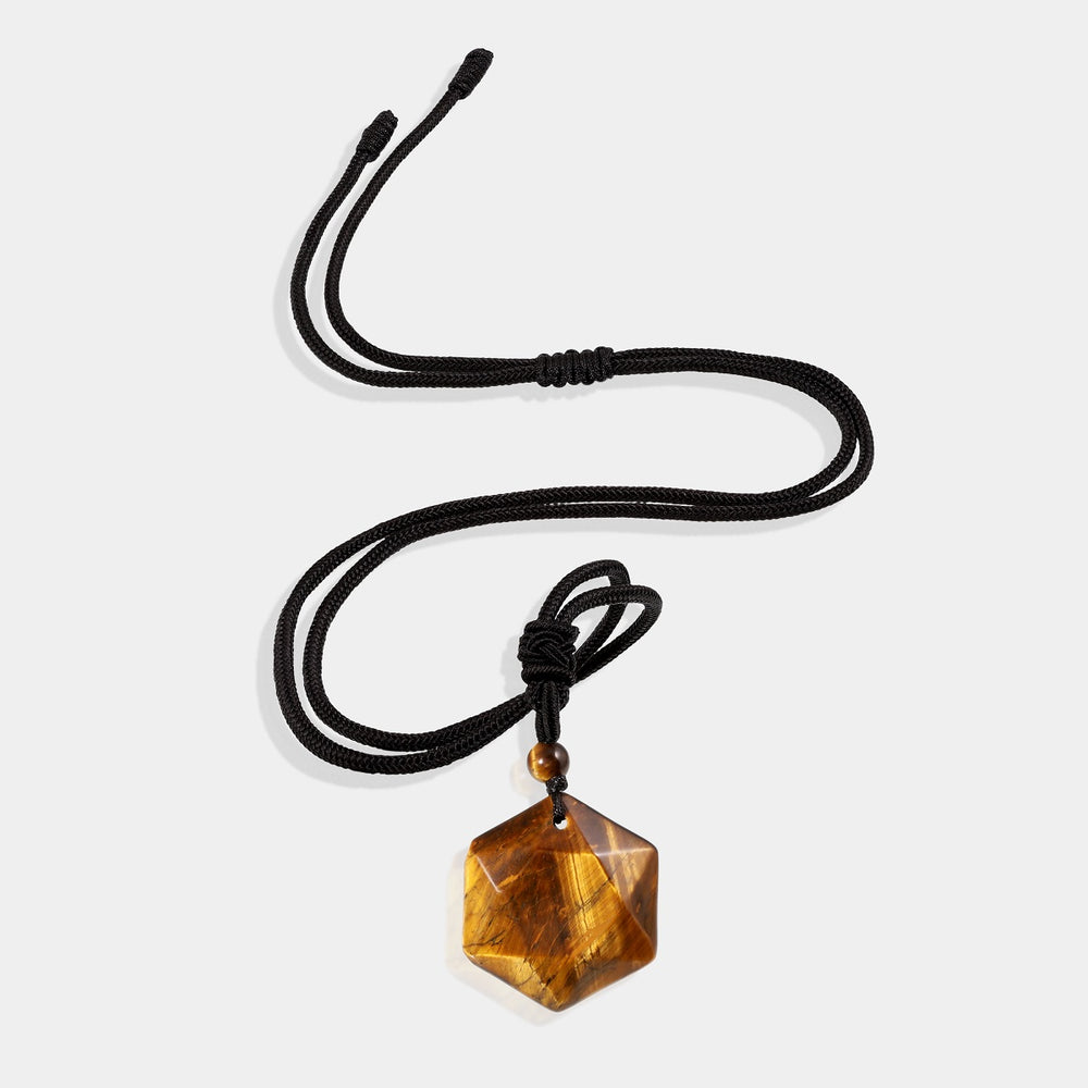 A stunning pendant necklace featuring a natural Tiger's Eye gemstone in a hexagon-cut, wrapped in an intricate design.