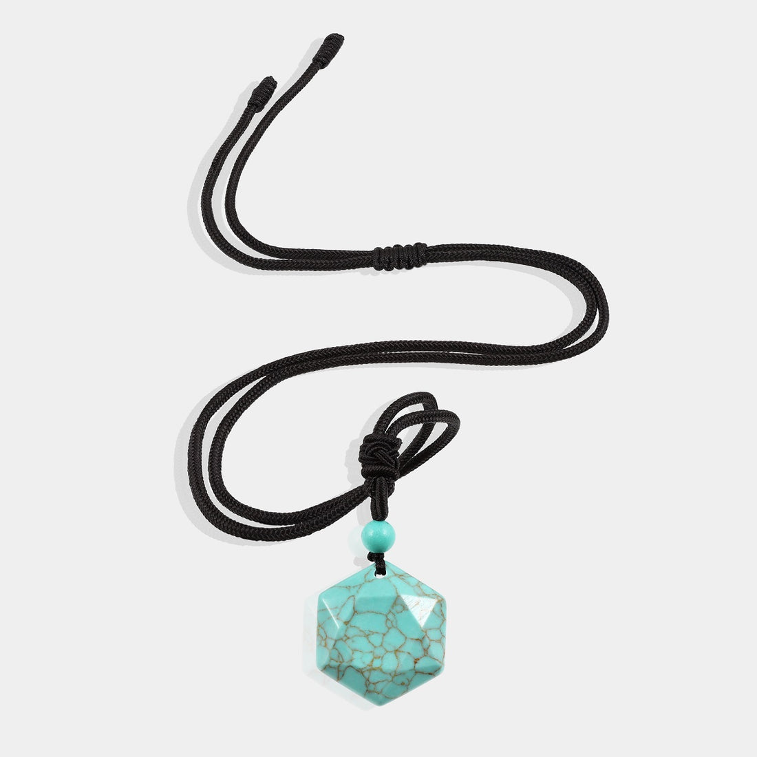 A stunning pendant necklace featuring a natural turquoise gemstone in a hexagon-cut, wrapped in an intricate design.