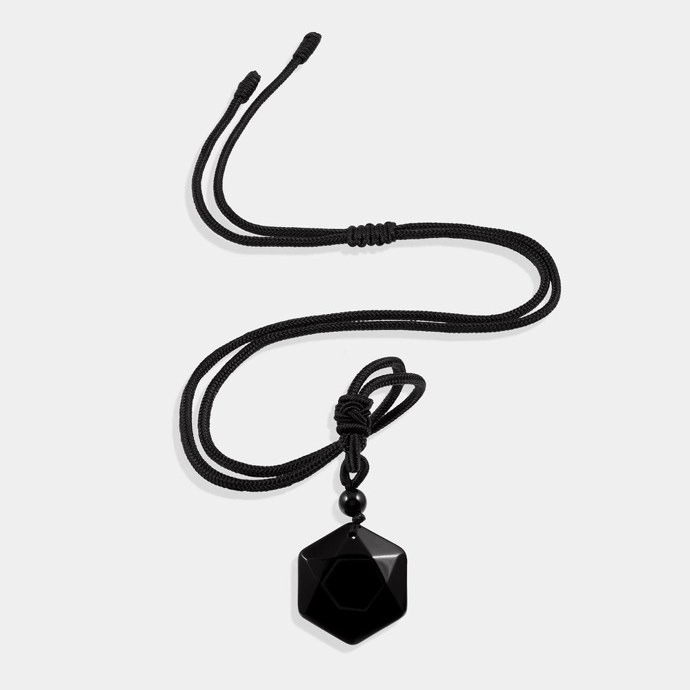 A stunning pendant necklace featuring a natural black onyx gemstone in a hexagon-cut, wrapped in an intricate design.
