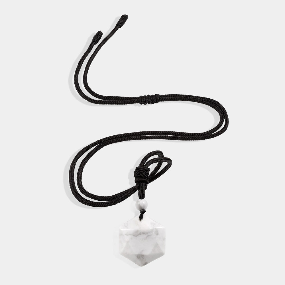 A stunning pendant necklace featuring a natural Howlite gemstone in a hexagon-cut, wrapped in an intricate design.