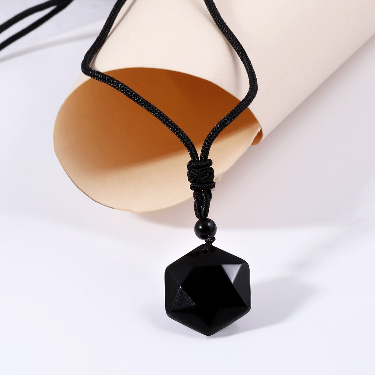 A detailed view of the artistic and intricate wrapping design that surrounds the black onyx gemstone, adding a touch of elegance to the pendant necklace.