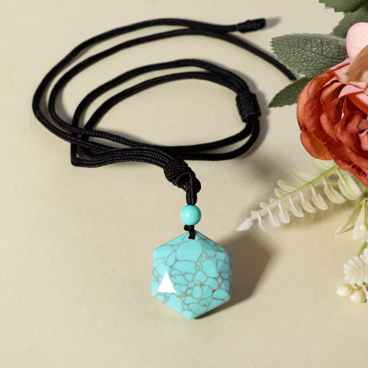 A detailed view of the artistic and intricate wrapping design that surrounds the turquoise gemstone, adding a touch of elegance to the pendant necklace.