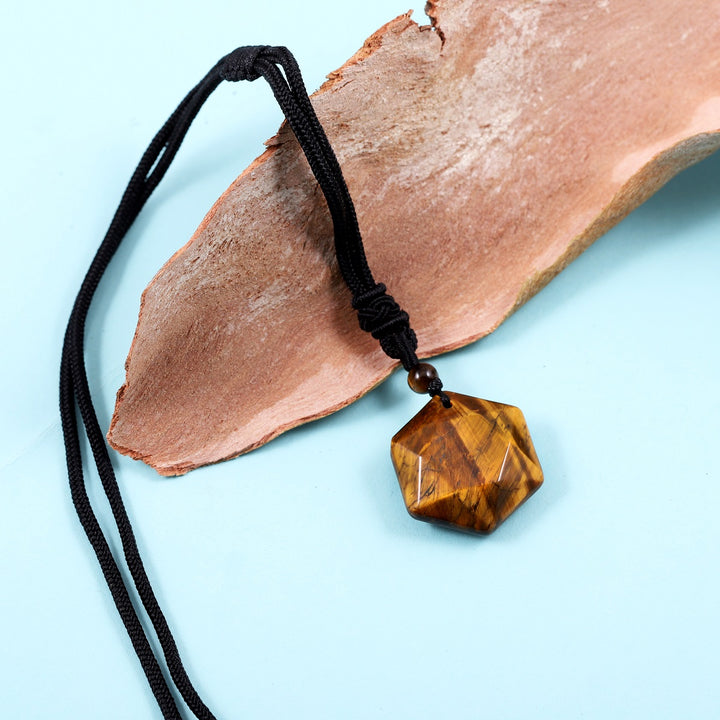 A detailed view of the artistic and intricate wrapping design that surrounds the Tiger's Eye gemstone, adding a touch of elegance to the pendant necklace.