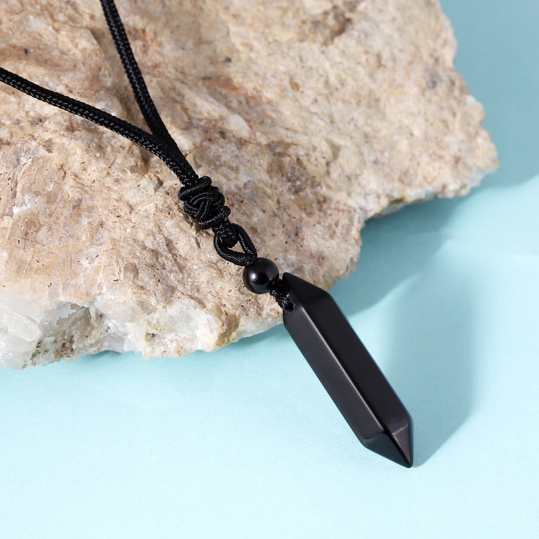 A detailed view of the artistic and intricate wrapping design that surrounds the black onyx gemstone, adding a touch of elegance to the pendant necklace.