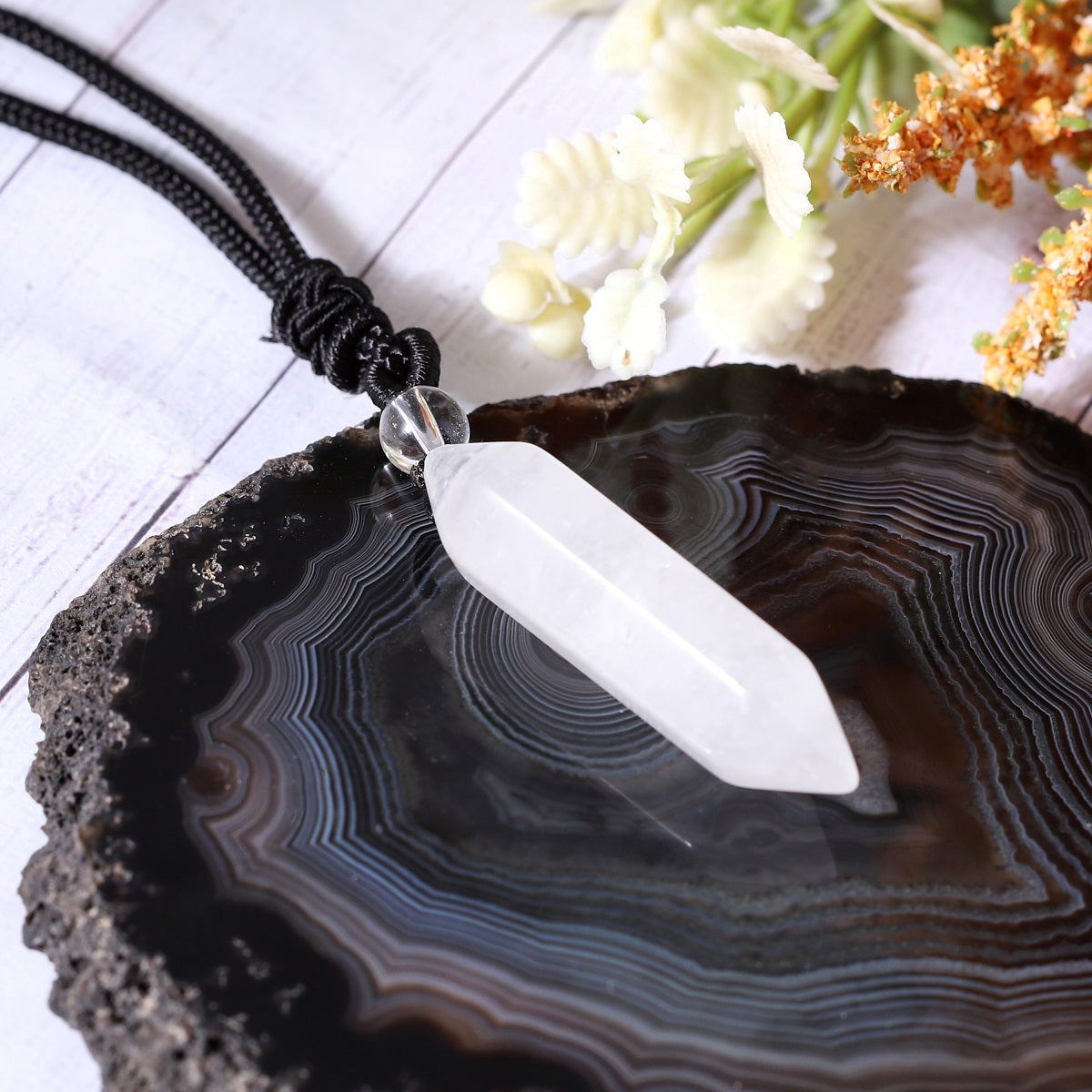 A detailed view of the artistic and intricate wrapping design that surrounds the white quartz gemstone, adding a touch of elegance to the pendant necklace.