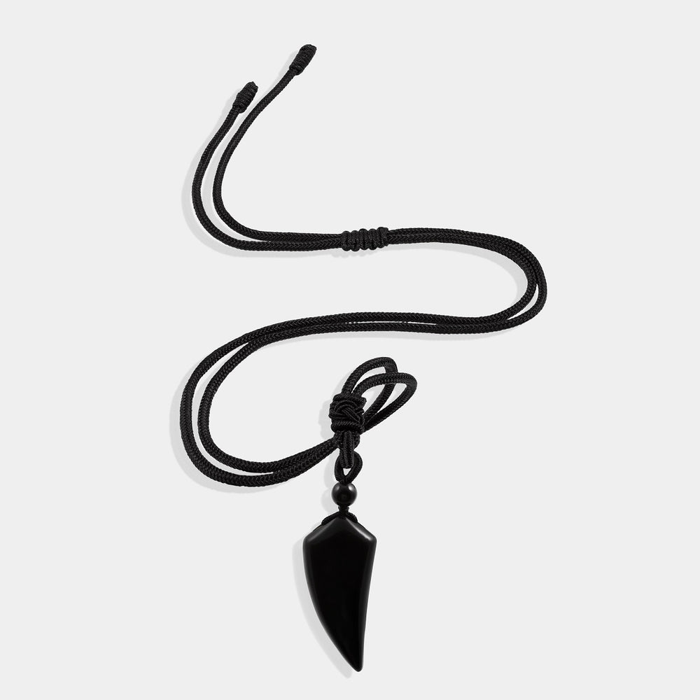 A close-up view of the pendant necklace showcasing the smooth fang tooth pendant wrapped with an adjustable rope necklace, featuring a stunning black onyx gemstone.