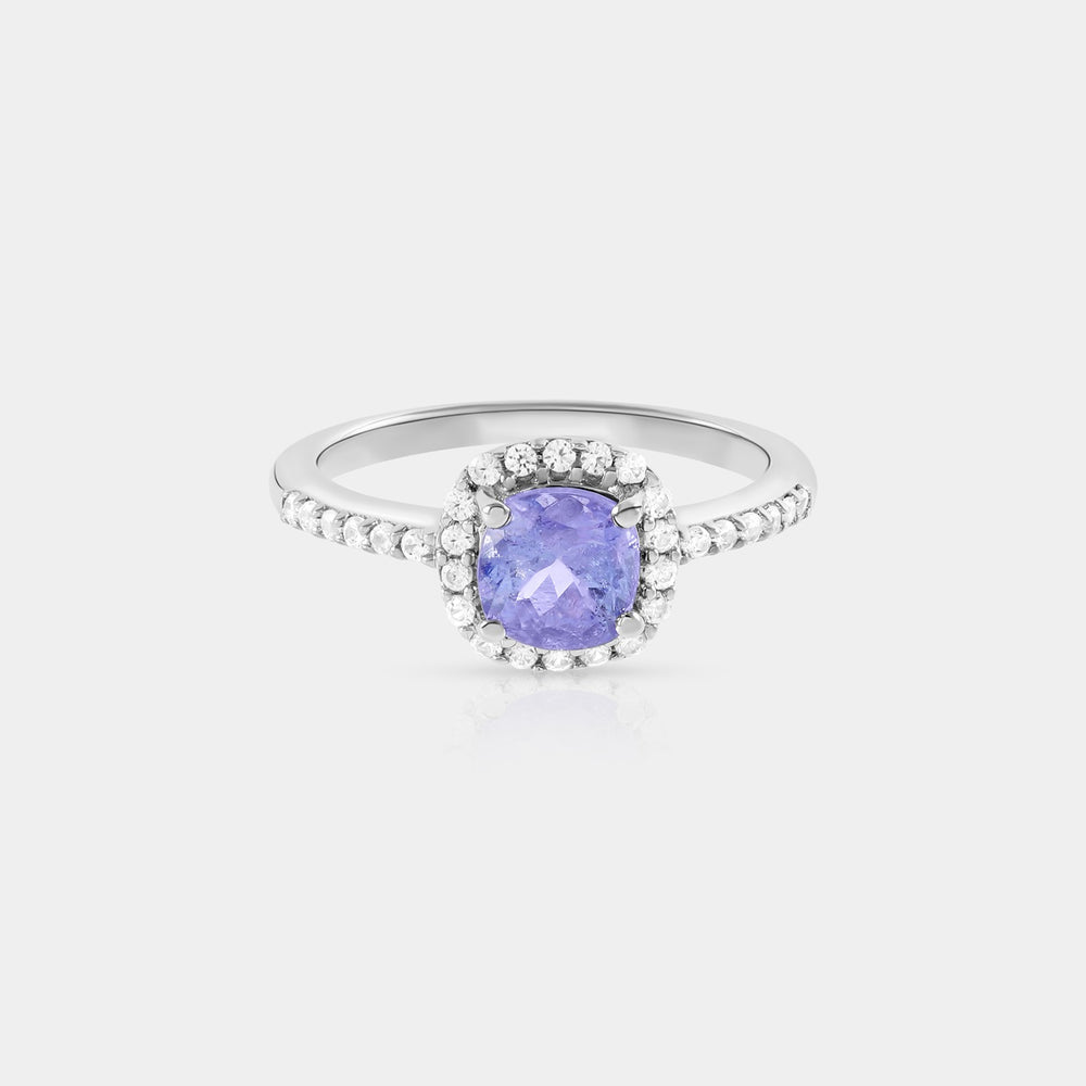 Close-up image capturing the mesmerizing details of the 6mm cushion-cut Tanzanite, revealing its vibrant blue hue and the expertly crafted prong setting