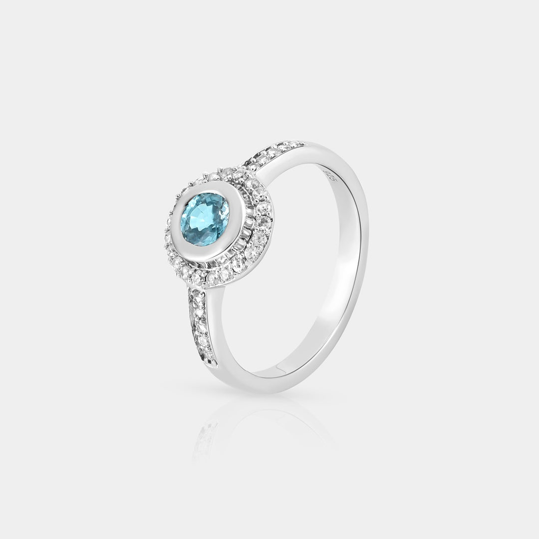 Side profile image emphasizing the intricate bezel setting of the Blue Zircon gemstone in the Halo Ring, showcasing its depth and sparkle.