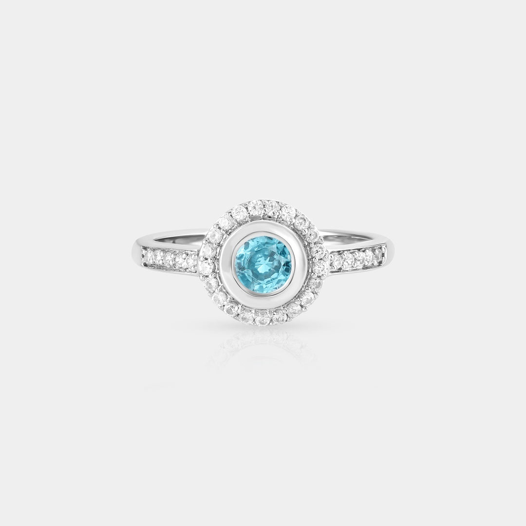 A mesmerizing top-down view showcasing the Blue Zircon Halo Ring, highlighting the brilliant blue hues of the central gemstone and surrounding halo.