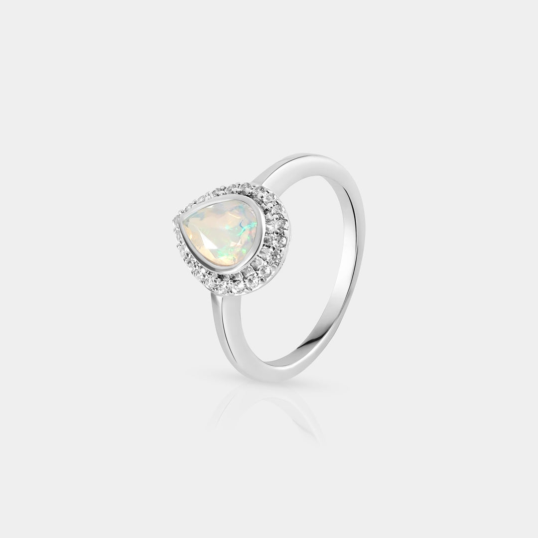 Side profile image highlighting the meticulous prong setting of the 0.65 Carat pear-shaped Ethiopian Opal, radiating an enchanting white glow